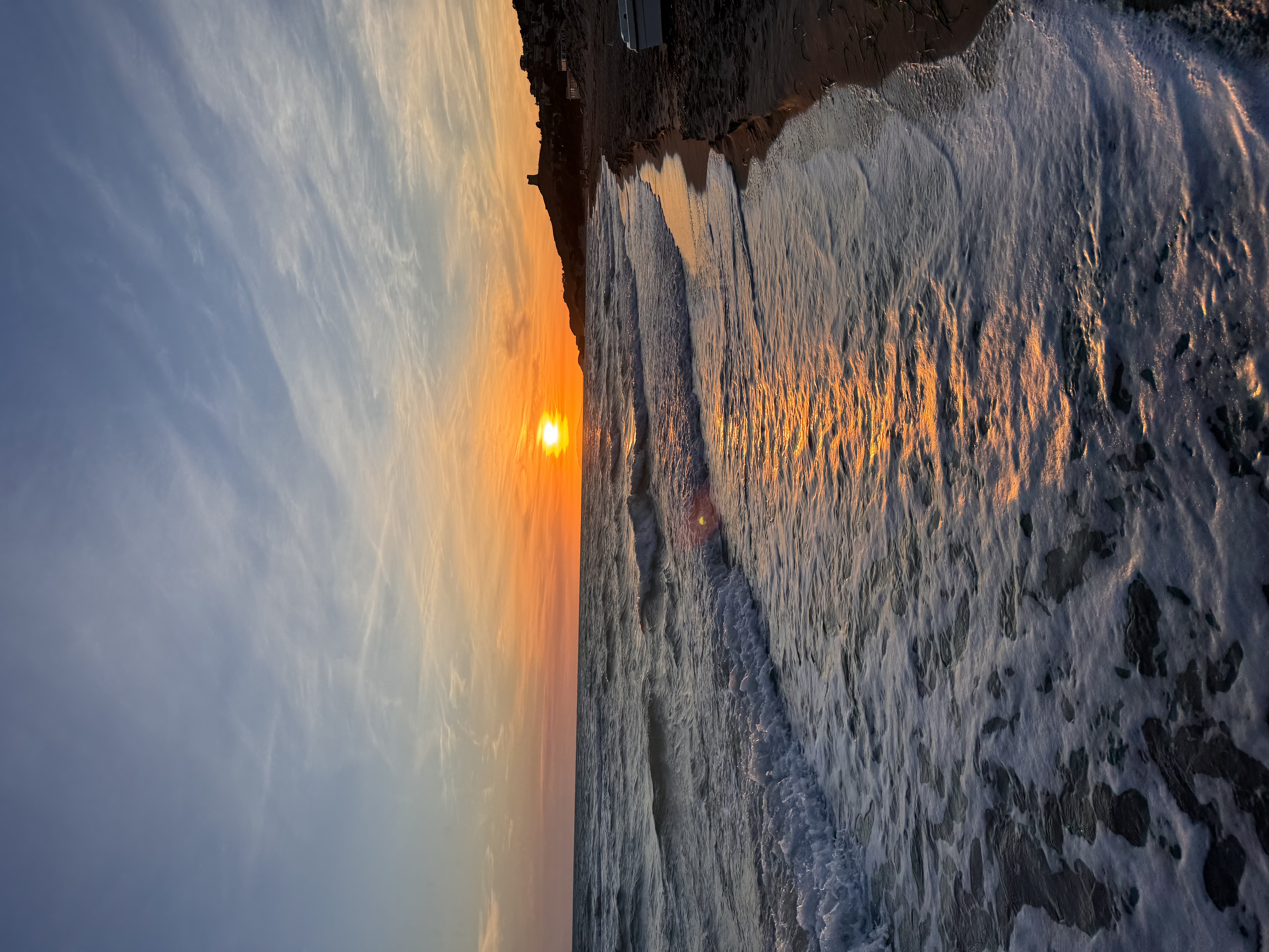Il litorale di Manfria al tramonto, la battigia e i riflessi sull'acqua
